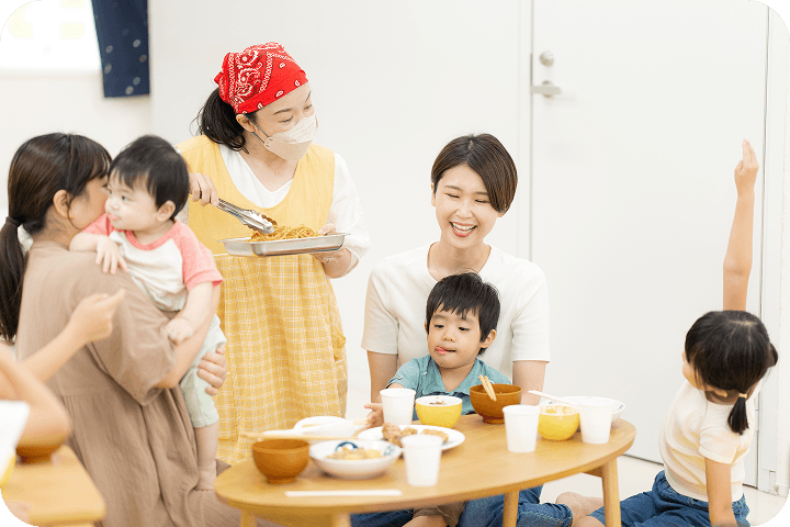 大人数で笑顔で食卓を囲んでいる画像