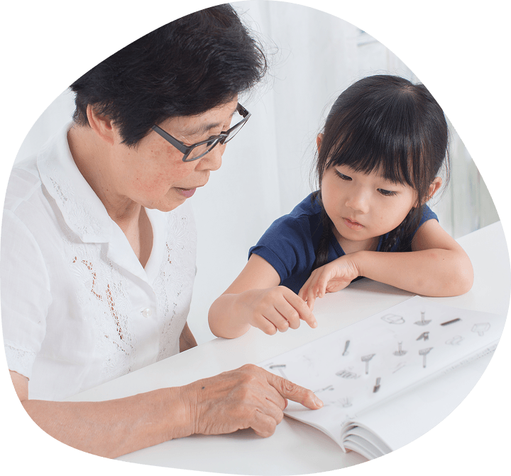 大人と子どもが本を一緒に見ながら学んでいる様子